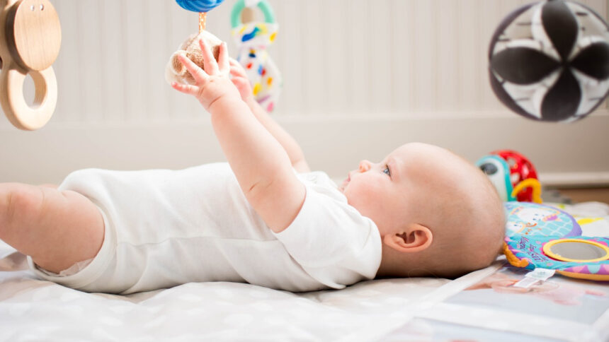 Bébé jouant dans une micro crèche avec des éducateurs attentifs