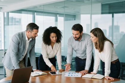 Groupe de quatre professionnels en réunion dans un bureau moderne