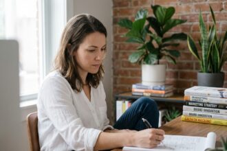 Femme en bureau moderne sketchant des idées en réfléchissant