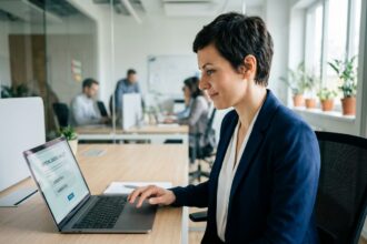 Femme en entreprise votant pour les élections CSE sur un ordinateur portable avec interface de vote électronique